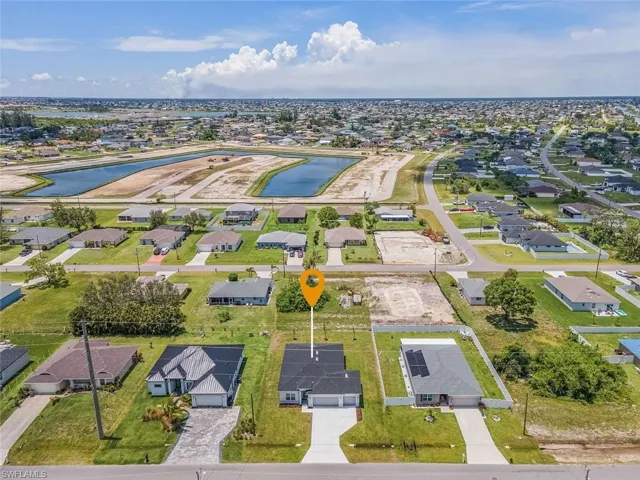 Aerial view of property's location featuring a nearby body of water and nearby suburban area