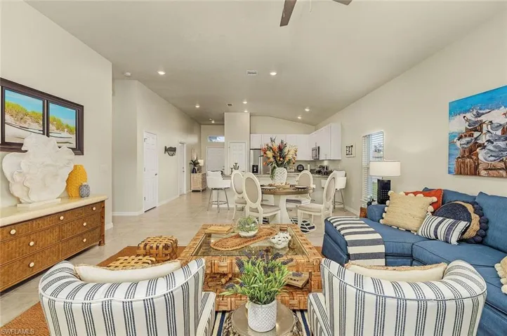 Living area featuring vaulted ceiling, recessed lighting, light tile patterned flooring, a ceiling fan, and plenty of natural light