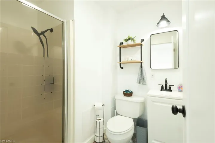 Bathroom featuring toilet, vanity, and walk in shower