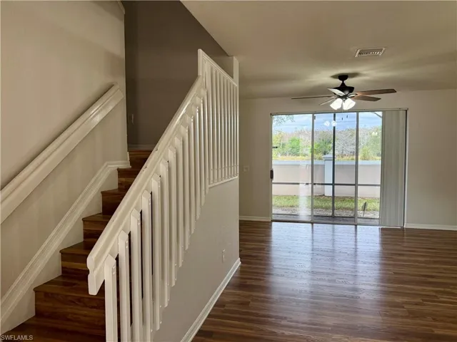 Stairs with wood finished floors and ceiling fan