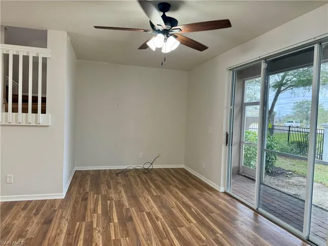 Unfurnished room with dark wood-type flooring and a ceiling fan