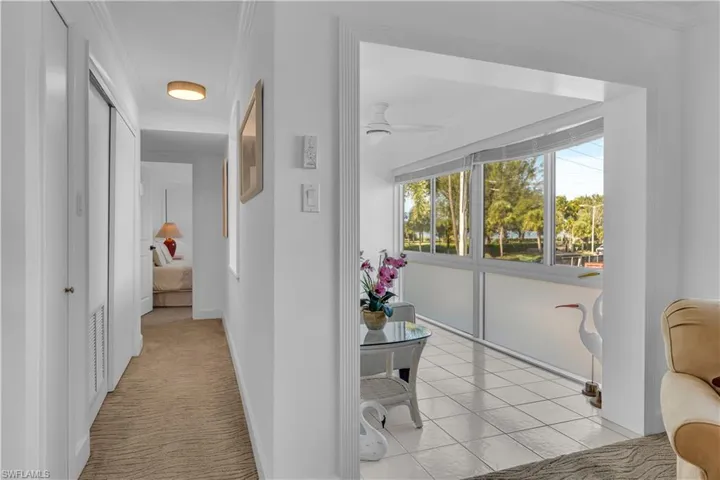 Hallway featuring crown molding and light colored carpet