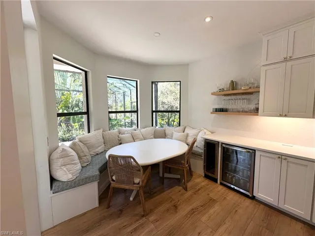 Dining area featuring bar, beverage cooler, and light hardwood / wood-style floors