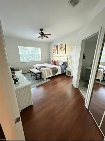 Bedroom featuring multiple windows, dark wood-style flooring, and a ceiling fan