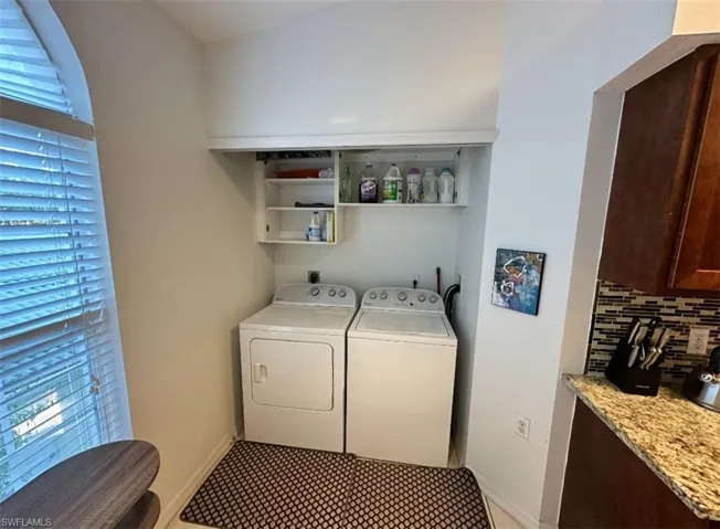 Laundry room featuring healthy amount of natural light and washing machine and clothes dryer