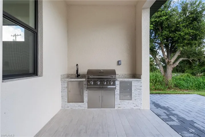 View of patio / terrace featuring an outdoor kitchen and a sink