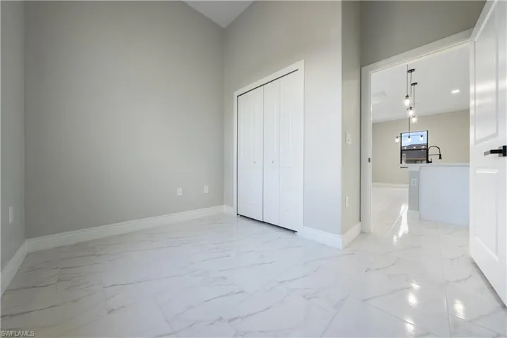 Unfurnished bedroom with light marble finish flooring and a closet
