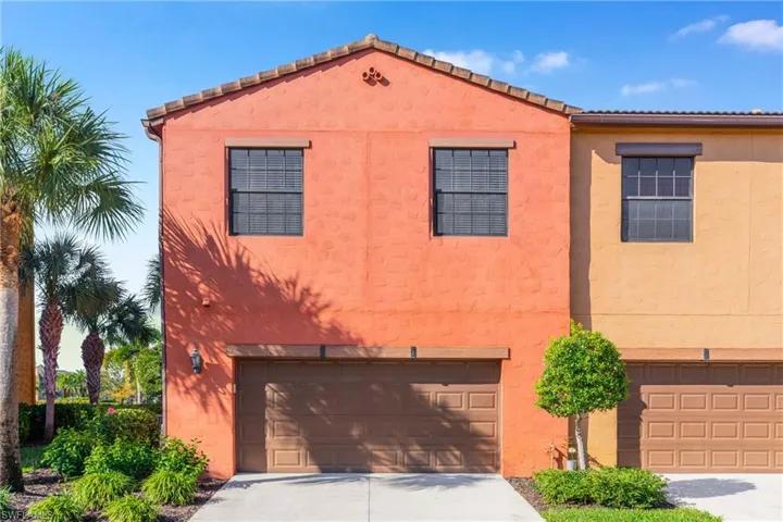 View of front of home featuring an attached garage, driveway, and stucco siding