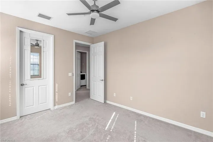 Unfurnished bedroom with a ceiling fan, carpet flooring, and washer / clothes dryer