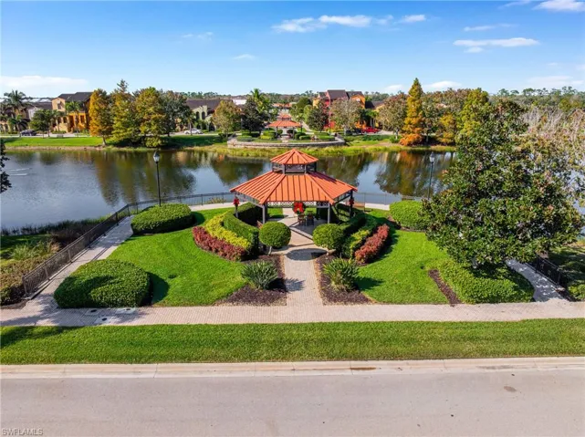 Surrounding community featuring a gazebo, a water view, and a lawn