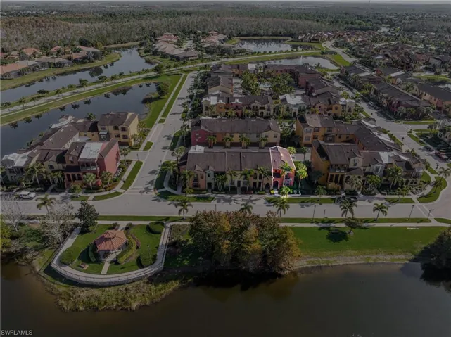 Aerial view of property and surrounding area with a nearby body of water and nearby suburban area