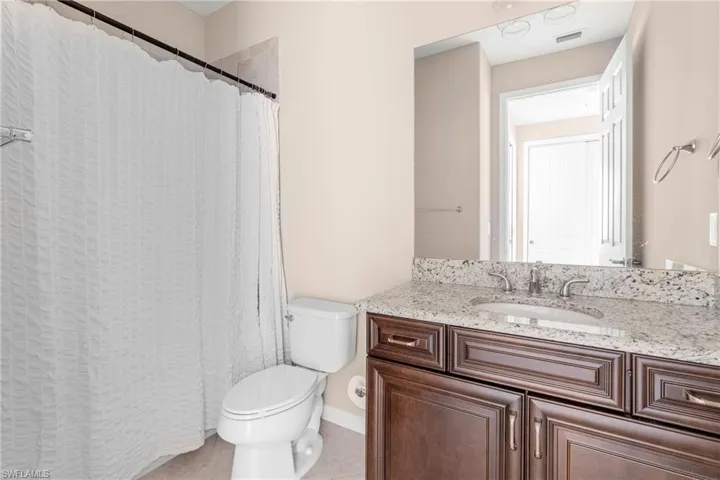 Bathroom featuring a shower with curtain, vanity, and light tile patterned floors