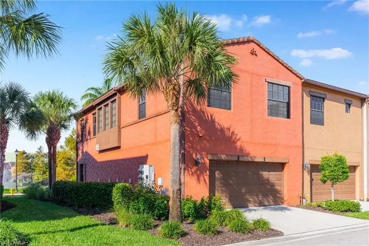 View of side of property with stucco siding, an attached garage, and driveway