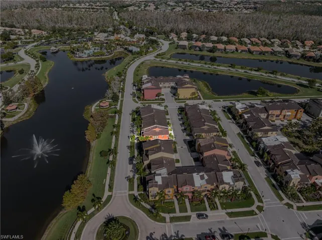 Aerial view of property and surrounding area featuring a nearby body of water and nearby suburban area