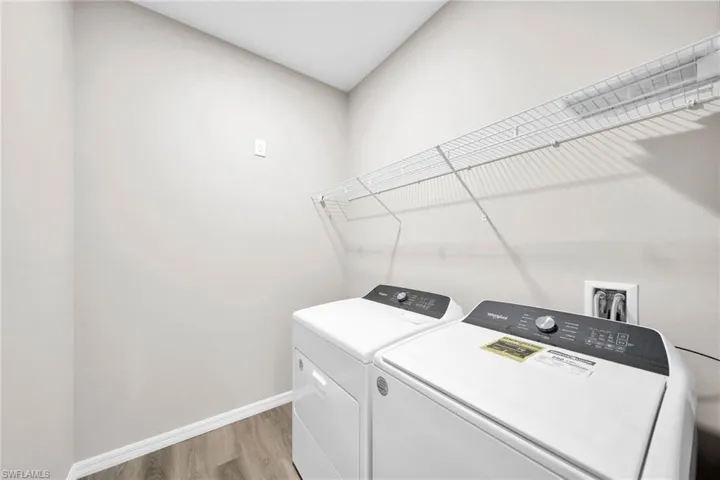 Laundry area with washing machine and dryer and light wood-type flooring