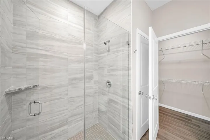 Bathroom with a shower with door and hardwood / wood-style floors
