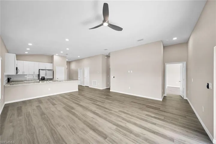 Unfurnished living room with vaulted ceiling, light hardwood / wood-style flooring, and ceiling fan