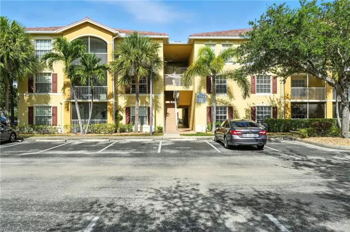 View of apartment building / complex featuring uncovered parking