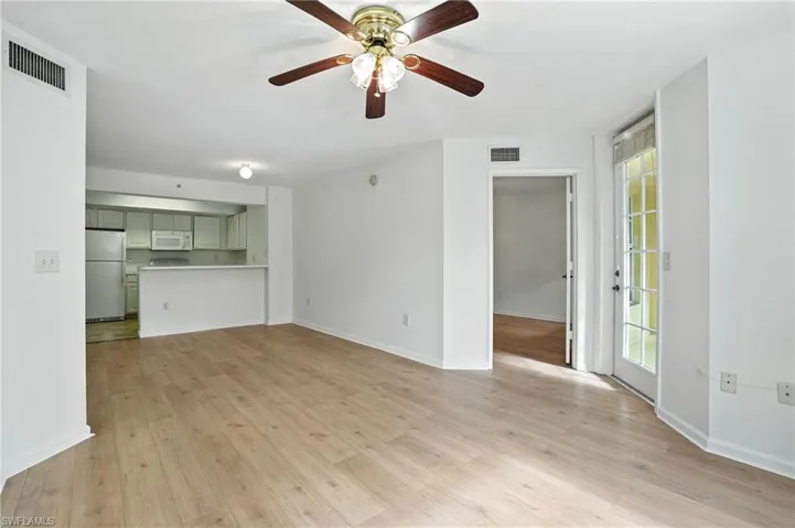 Unfurnished living room featuring light wood-type flooring and ceiling fan
