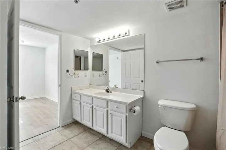 Bathroom with vanity, a textured ceiling, and light tile patterned floors