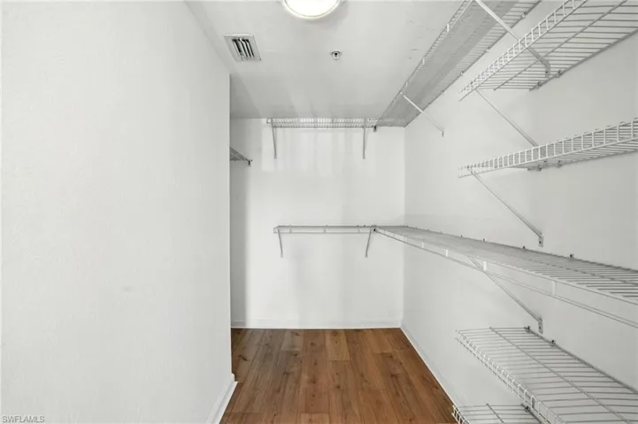 Walk in closet featuring dark wood-style flooring