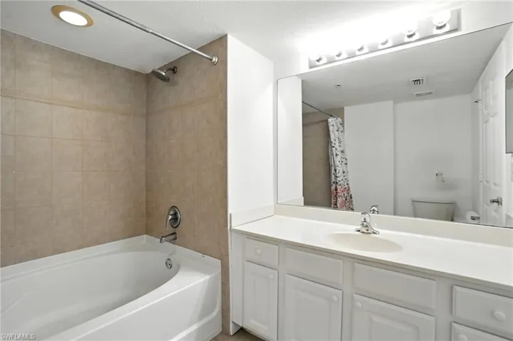 Bathroom featuring vanity and shower / bath combo with shower curtain