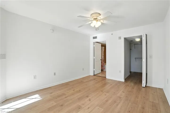 Unfurnished bedroom with light wood finished floors, a walk in closet, and ceiling fan