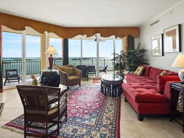 Living room with a water view, crown molding, and light tile patterned floors