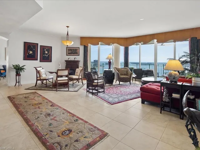 Living room with healthy amount of natural light, light tile patterned floors, a fireplace, and a water view