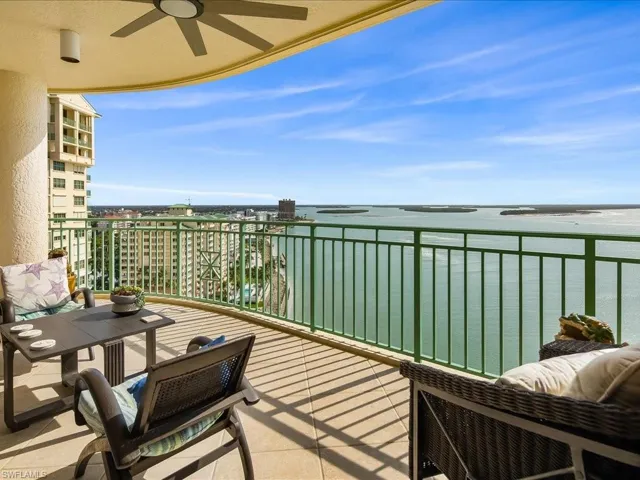 Balcony with ceiling fan, a water view, and a sunroom