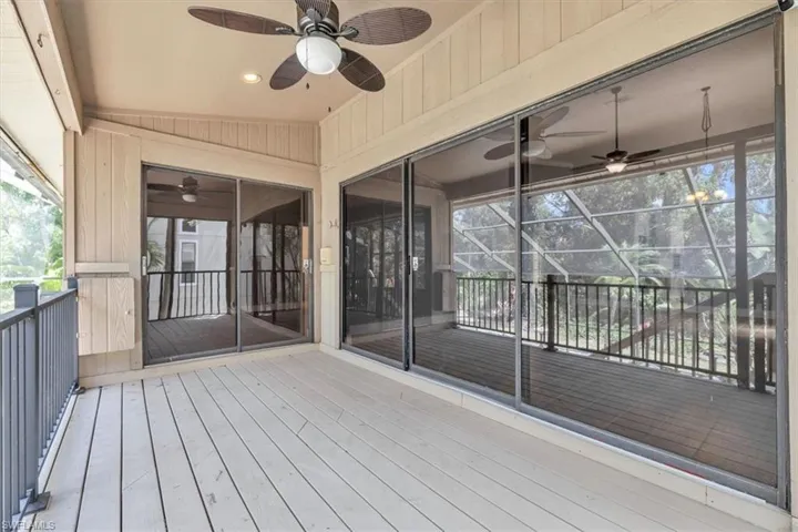 Screened outdoor living area featuring wood-finish flooring and a ceiling fan