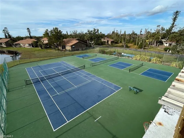 Dedicated tennis court and multiple pickleball courts featuring a green and blue surface