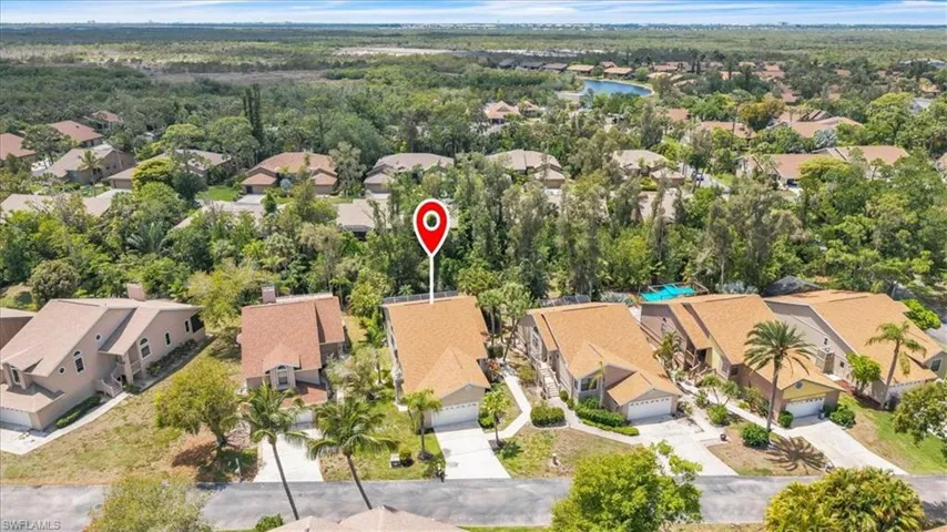 Aerial view showcasing a residential property with a light brown shingle roof and a two-car garage