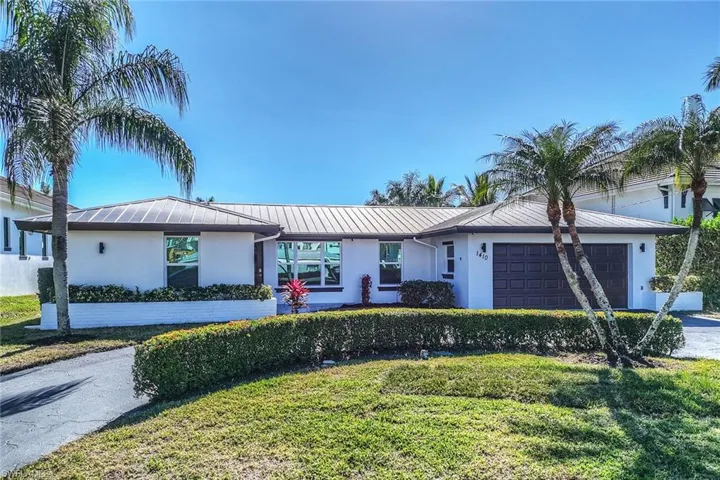 Front of home with 2 car garage and circular driveway