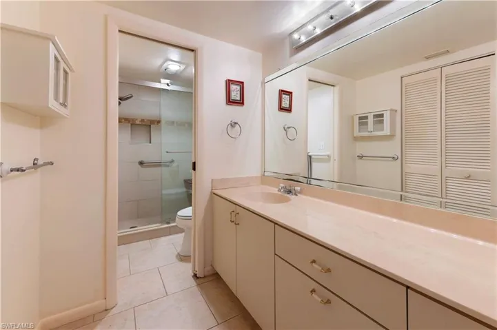 Full bathroom with vanity, a closet, light tile patterned floors, and a stall shower