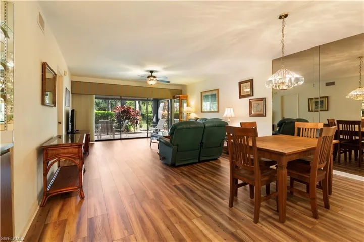 Dining area with ceiling fan, wood finished floors, and hanging lights