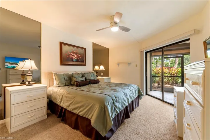 Bedroom with access to lanai, light colored carpet, and ceiling fan