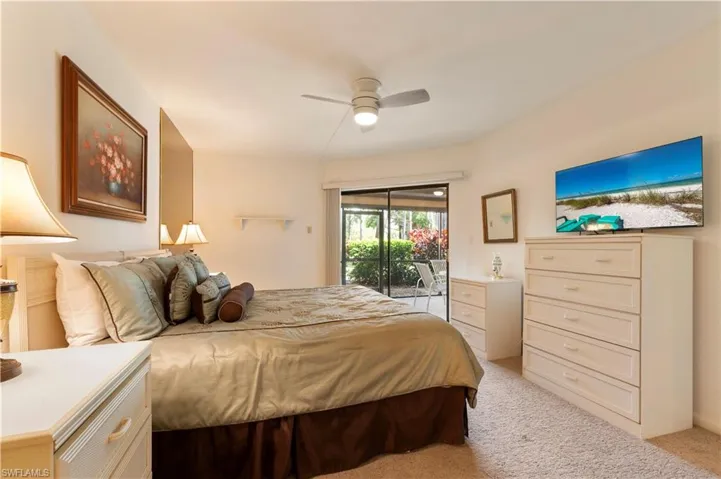 Bedroom with access to outside, light carpet, and a ceiling fan