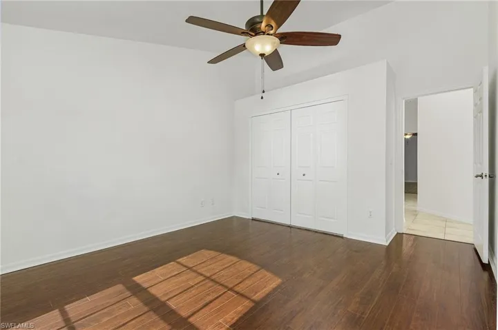 Unfurnished bedroom with a closet, hardwood / wood-style flooring, and ceiling fan