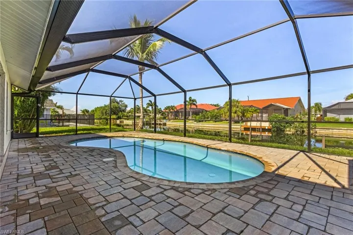View of swimming pool featuring a yard, a patio area, and a lanai