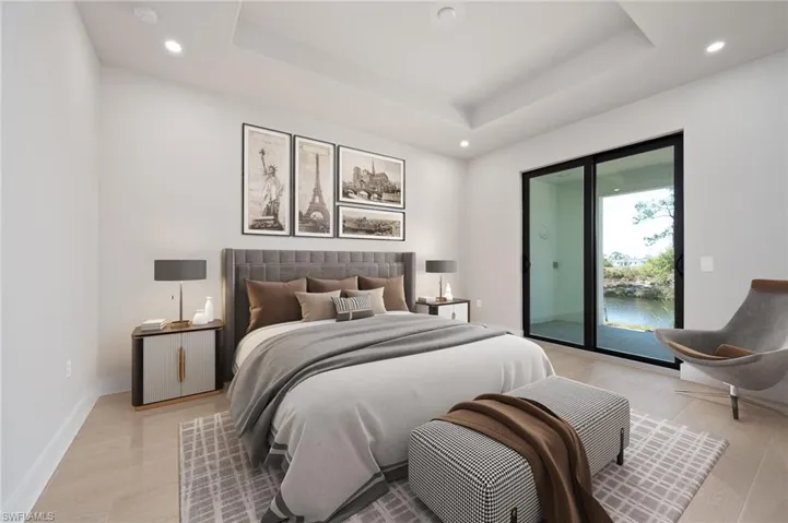 Bedroom with recessed lighting, access to outside, a raised ceiling, light wood-style flooring, and a water view