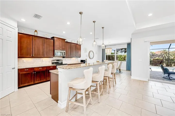 Kitchen features stainless appliances and a large pantry.