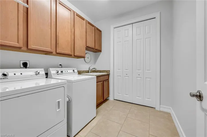 Spacious laundry room with PLENTY of extra storage.