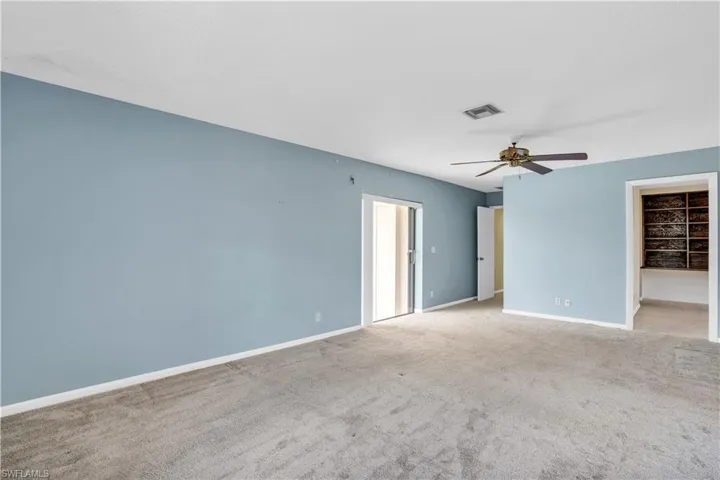 Empty room featuring carpet flooring and ceiling fan