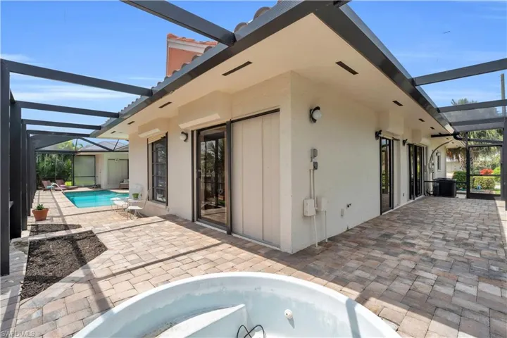 Back of property featuring a lanai and a patio area