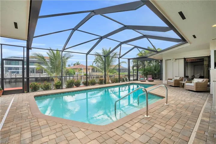 View of swimming pool featuring a patio area and a lanai