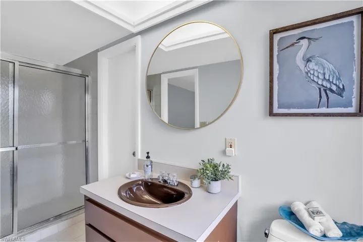 Bathroom with a shower with shower door, oversized vanity, toilet, and tile floors