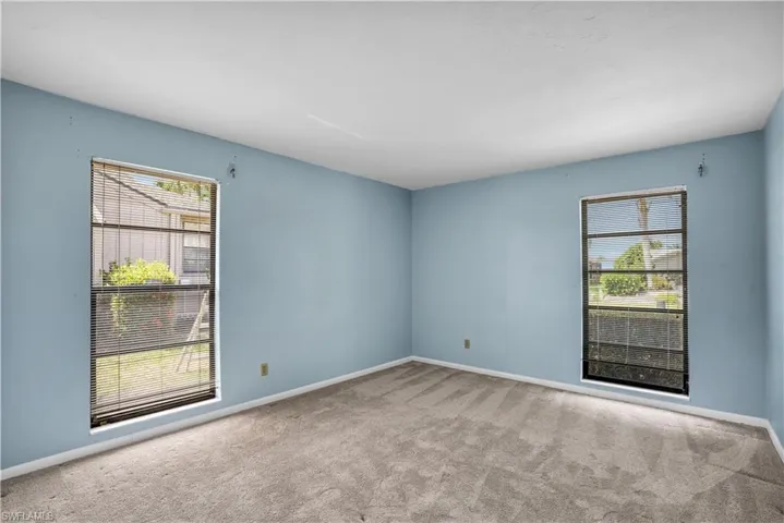 Carpeted spare room featuring a wealth of natural light