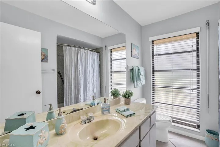 Bathroom featuring tile flooring, vanity with extensive cabinet space, and toilet