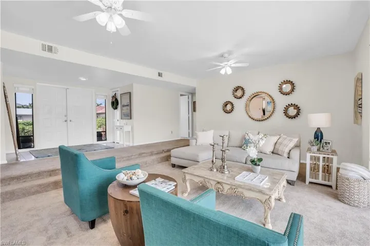 Living room with carpet and ceiling fan